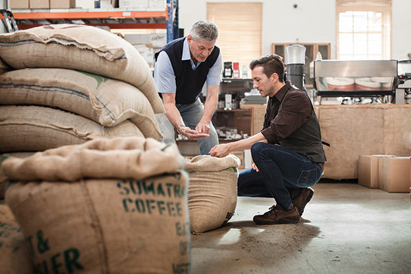 two coffee roaster business employees inspecting their inventory