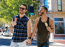 two men walking together holding hands and having ice cream cones