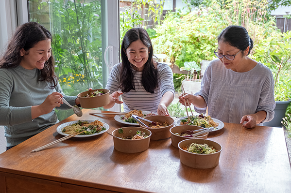 3 generations of asian women sitting at a table eating together