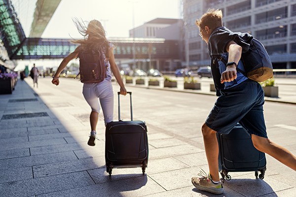 young couple running with their suitcases at the airport