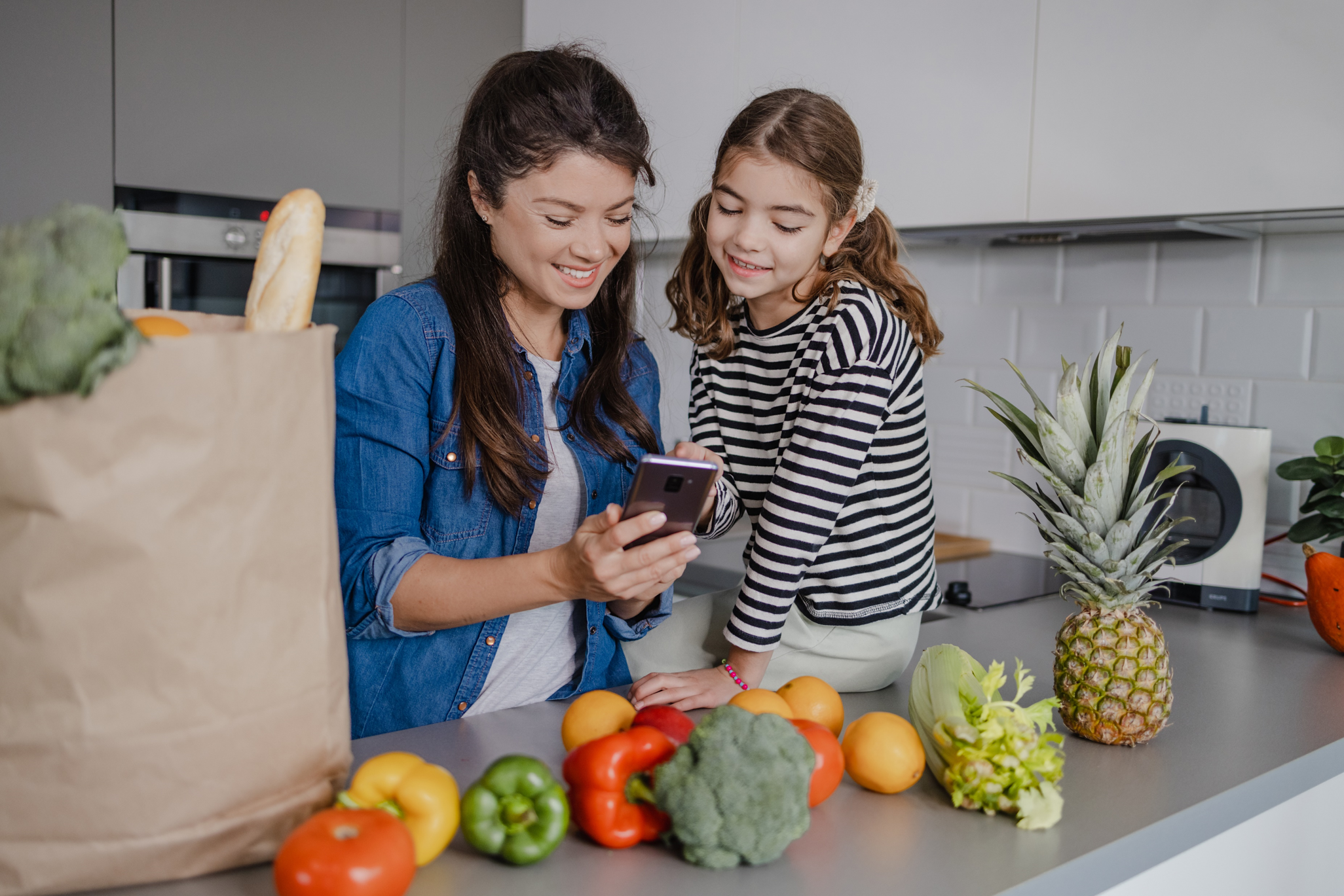mom and daughter unpacking groceries