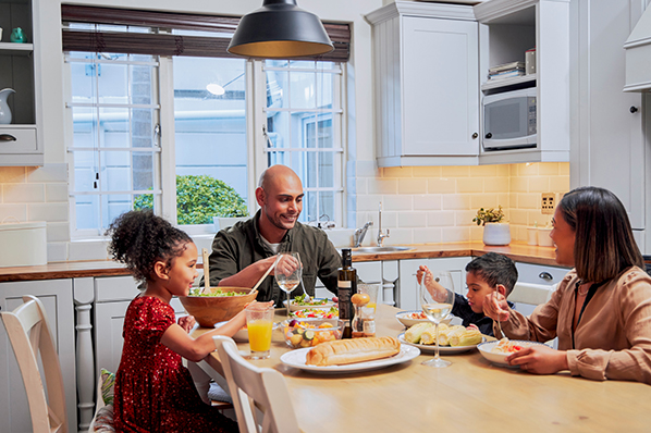 young family sitting down at the dinner table having dinner together