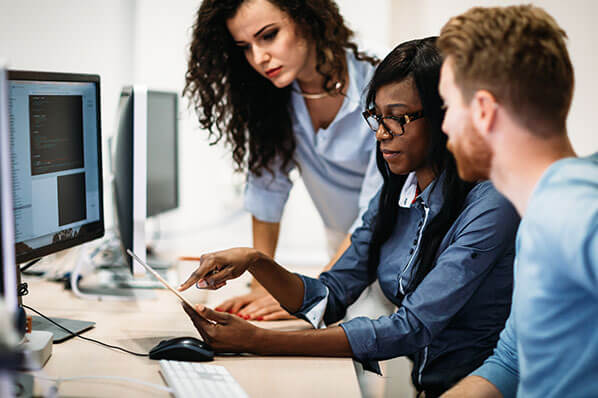 a group of coworkers looking at a computer