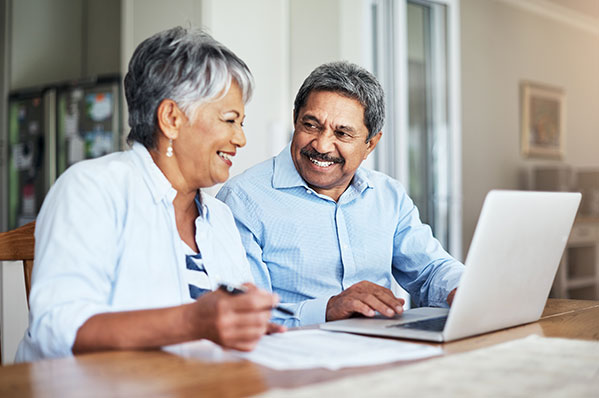 Older couple laughing with laptop