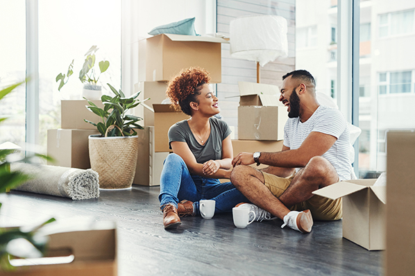 couple sitting together smiling with moving boxes.jpg