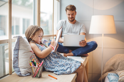 dad-on-tablet-with-daughter-colouring.jpg