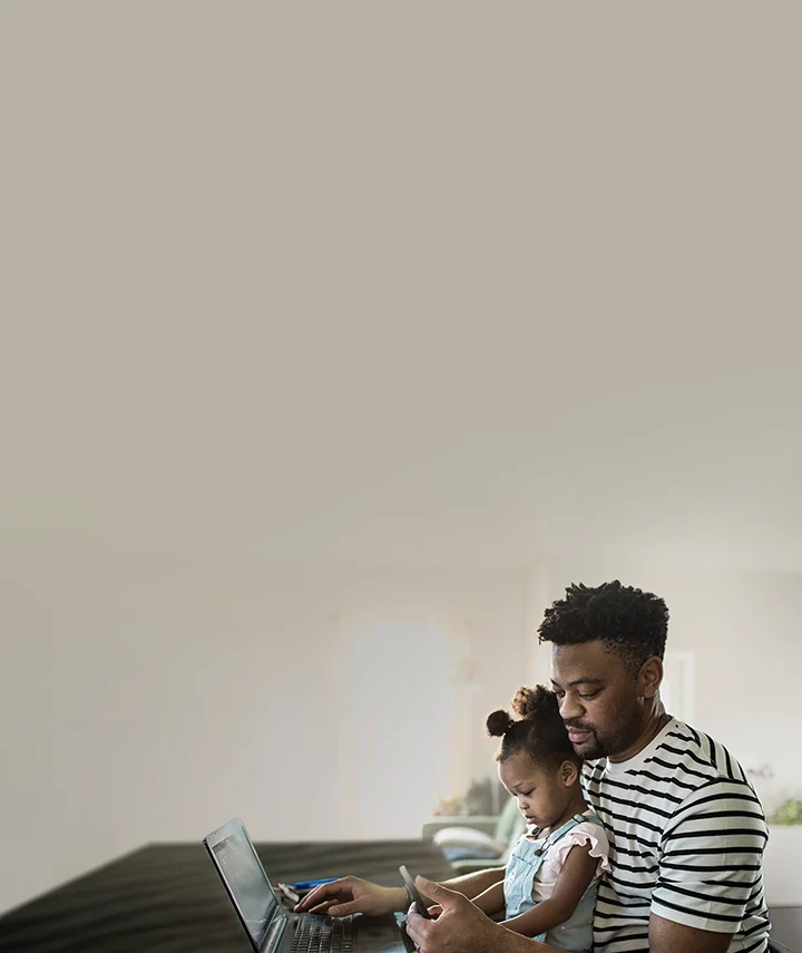 dad doing online banking with daughter sitting on his lap